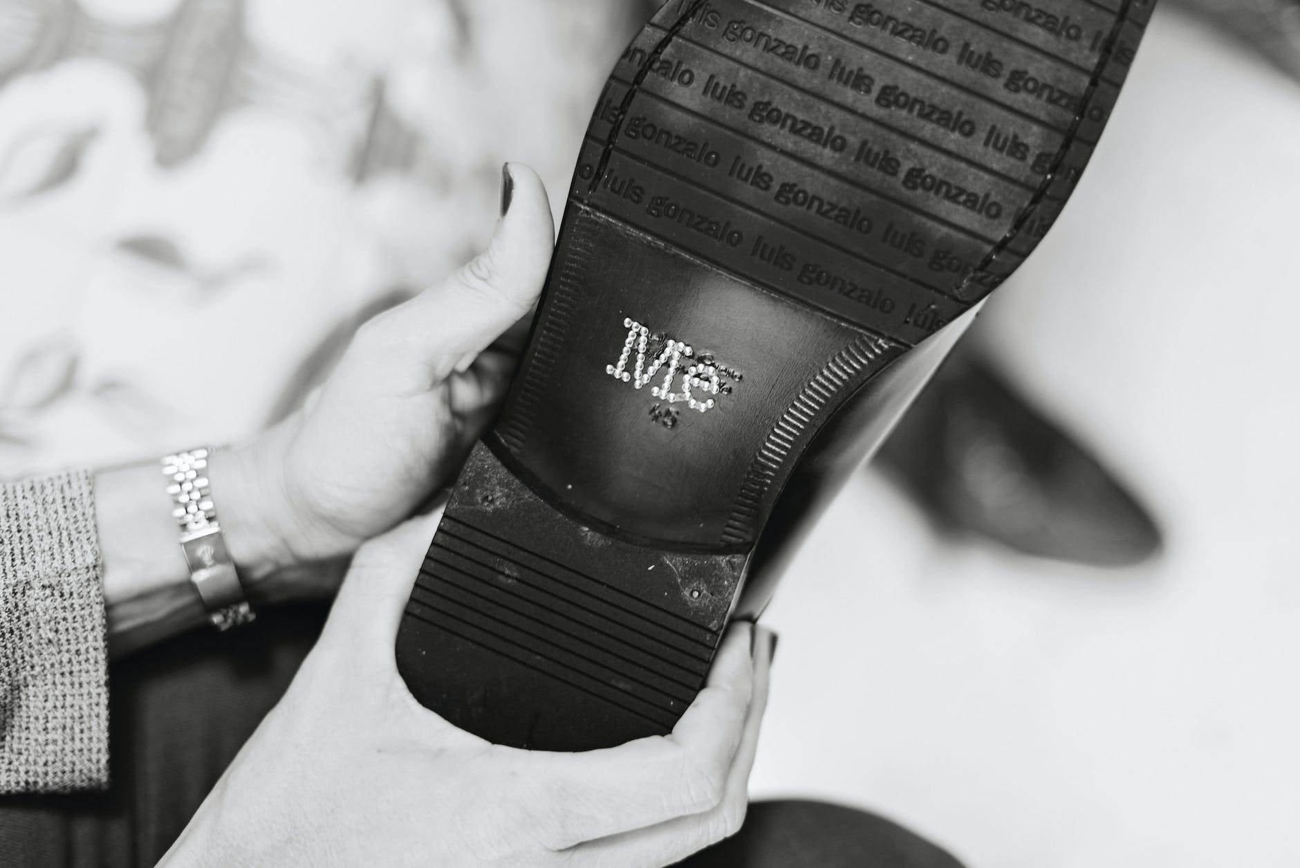 woman hands holding shoes with text on shoe sole